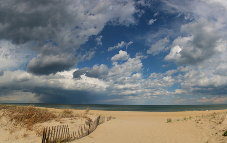 Beach With Clouds And A Wooden Fence