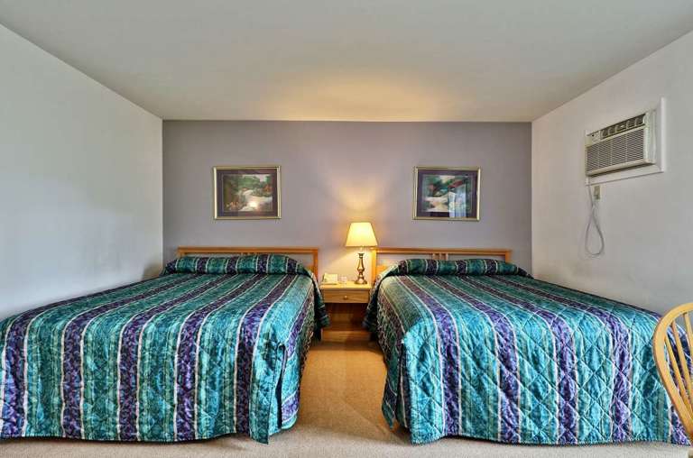 Hotel style setting with two double beds and small table for two