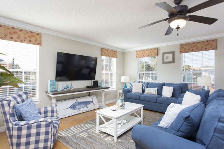 Living room with large flat screen TV and ample seating for guests.