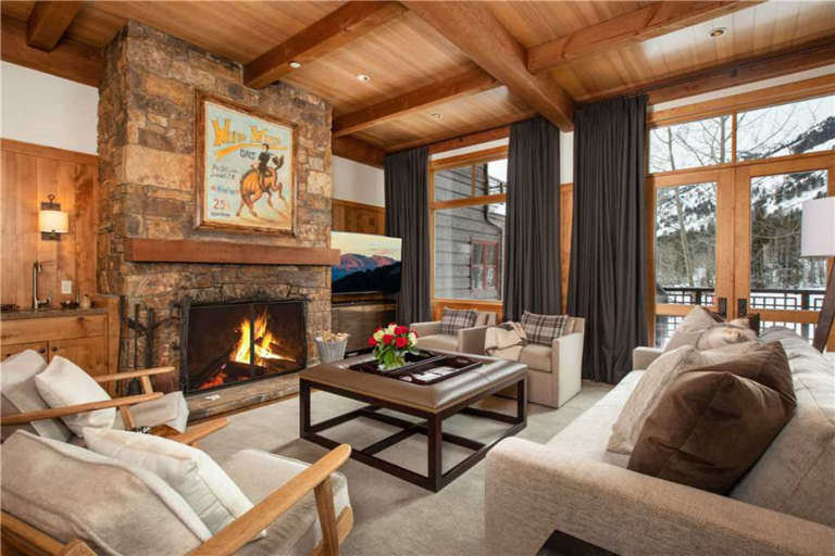 Living Room with a Stone Fireplace and Mountain Views