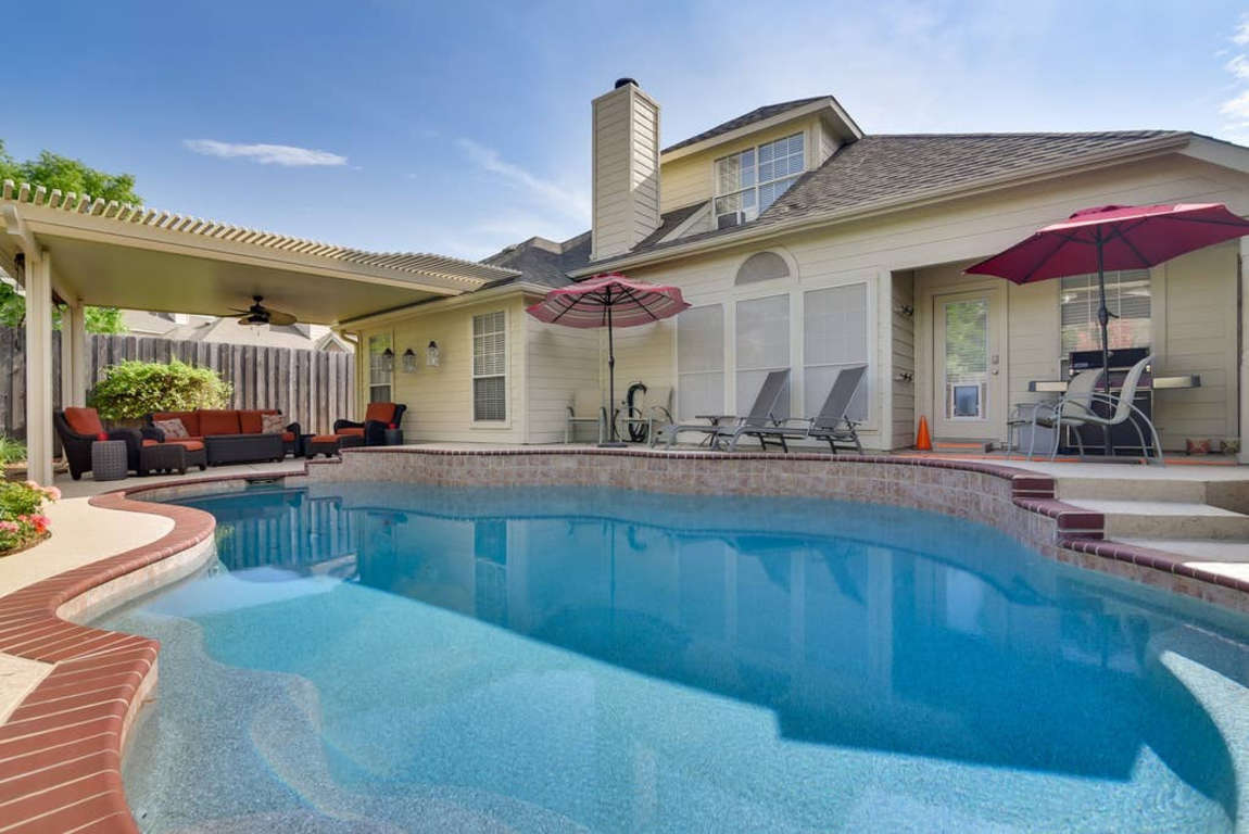 Backyard Pool with Tanning Ledge,  Covered Patio, Lounging chairs, Bluetooth Speakers, Grill, and Privacy fence.