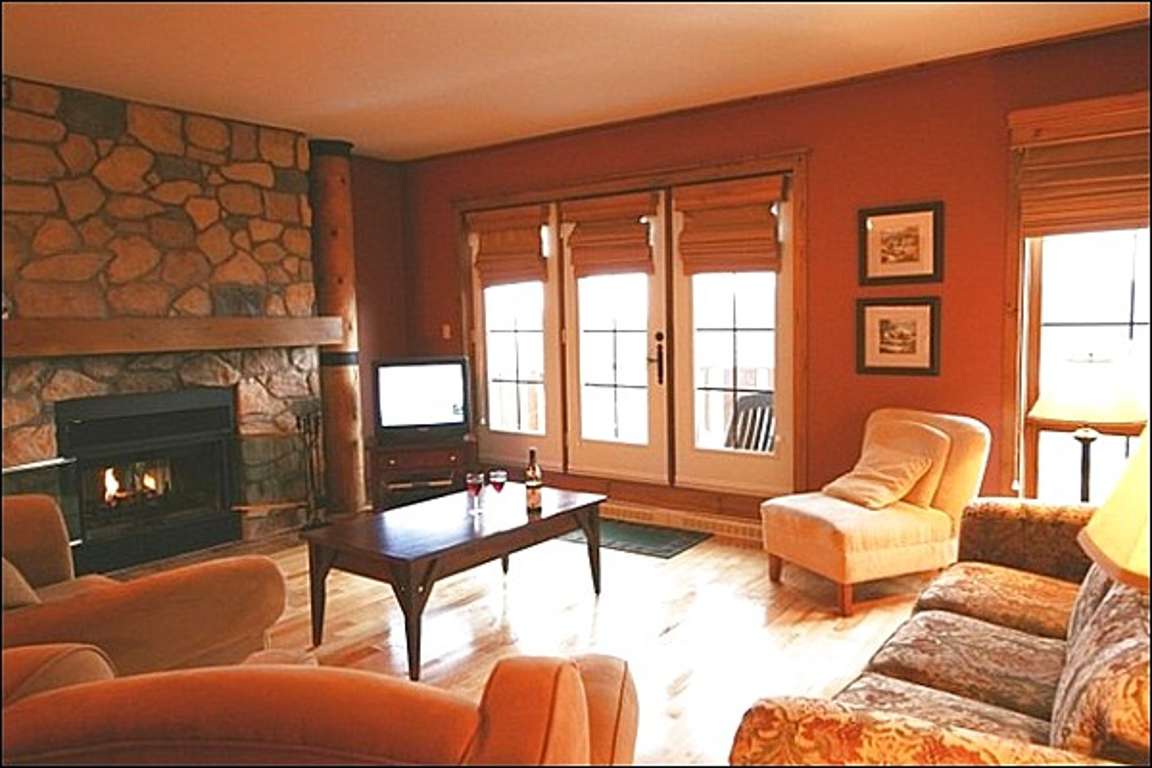The Cozy Living Area Featuring a Stone Fireplace