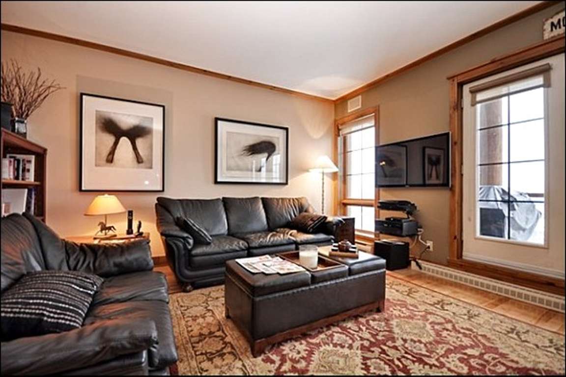 Living Room has Stunning Hardwood Floors and Comfy Leather Couches